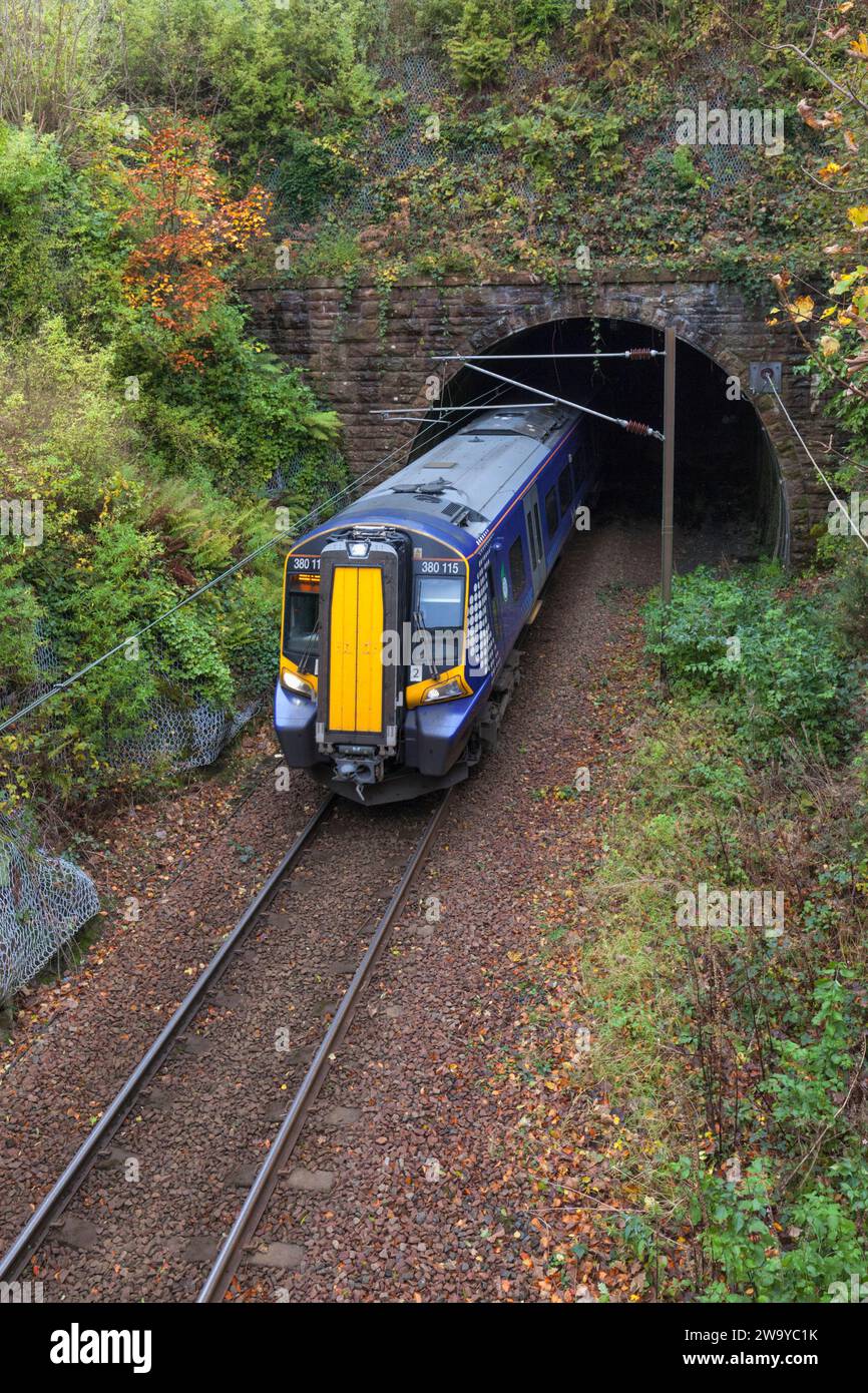 ScotRail Siemens-Elektrozug der Baureihe 380, der aus dem Fairlie-Tunnel auf der elektrifizierten eingleisigen Largs-Strecke hervorgeht Stockfoto