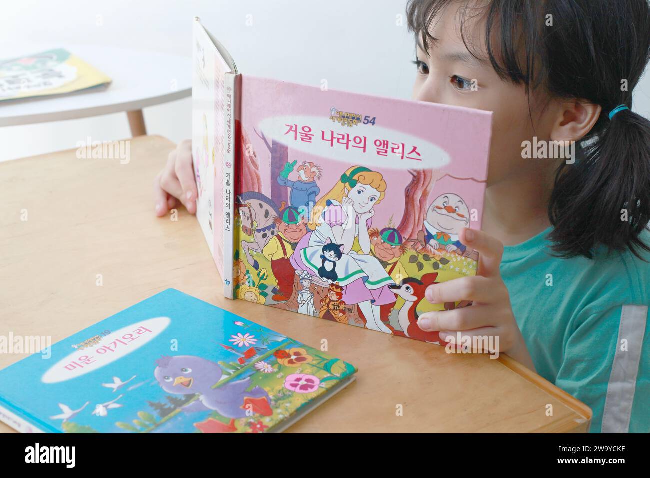 Asiatisches Mädchen liest Buch in koreanischer Hangul-Sprache. Stockfoto