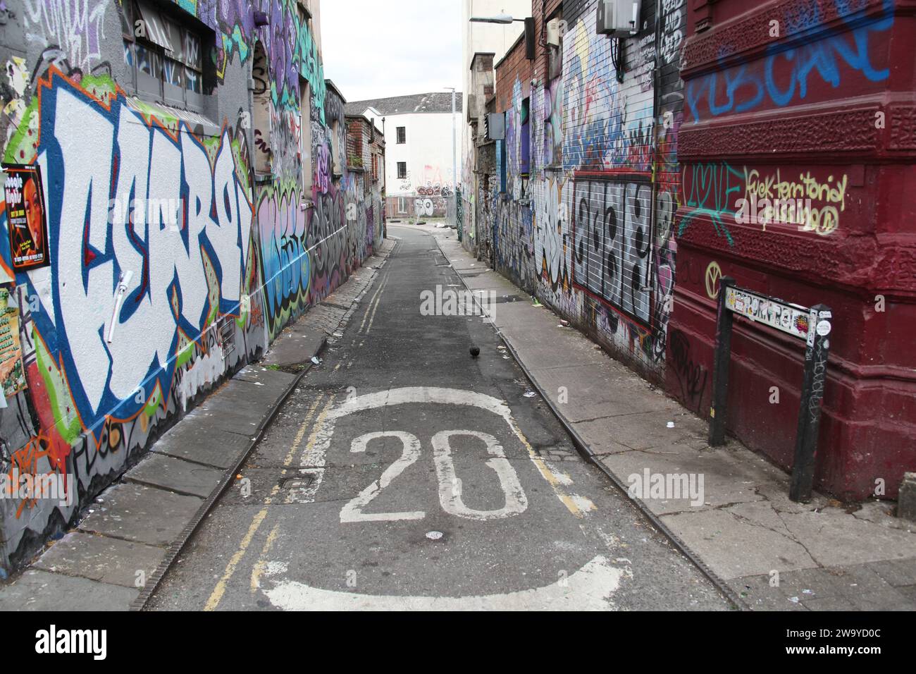 Stokes Croft, Bristol, Somerset, UK 06 16 2018 Eine mit Graffiti bedeckte Seitenstraße, in der die Geschwindigkeit des Verkehrs einen herausragenden Teil der Aussicht spielt. Stockfoto