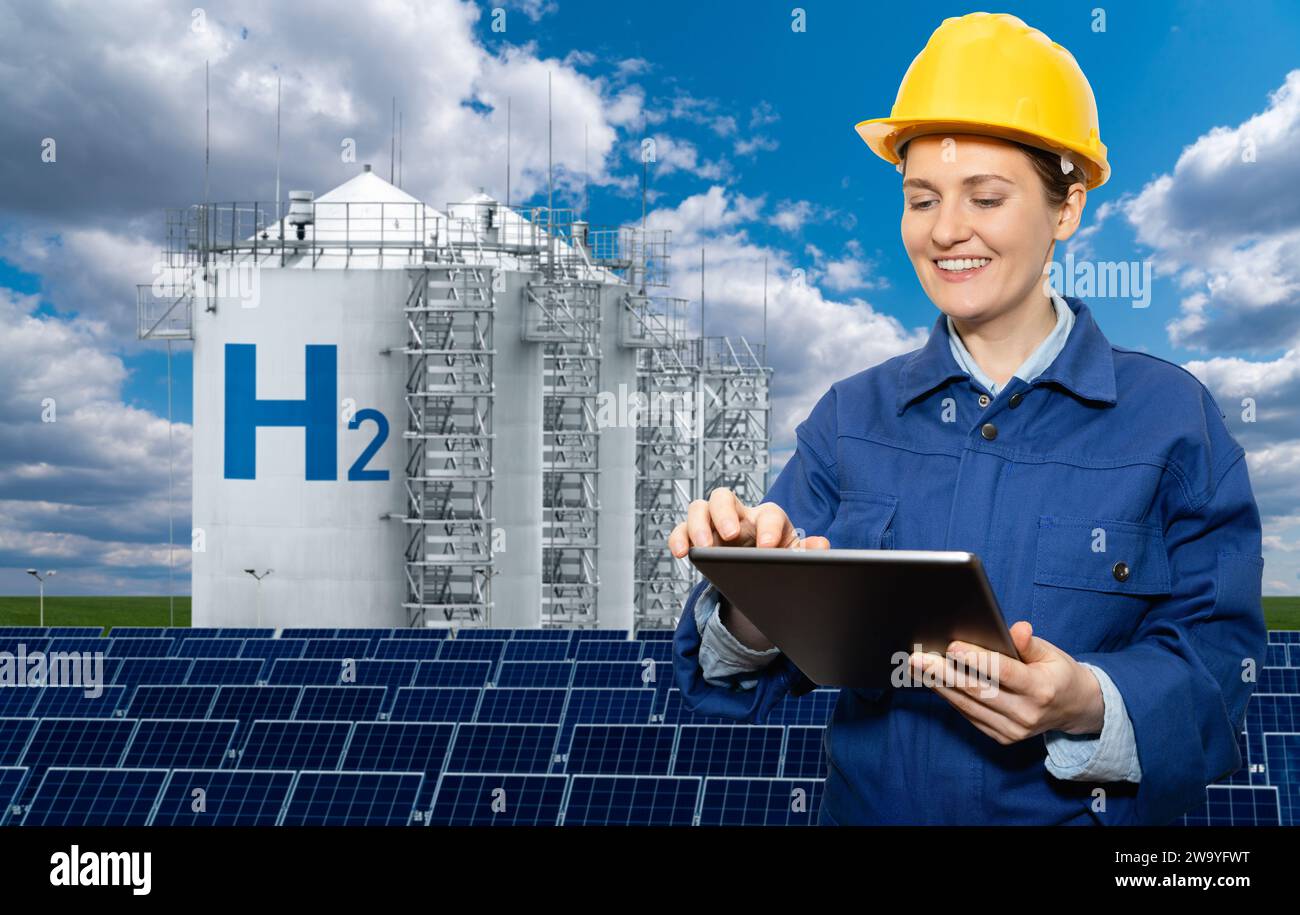 Weibliche Ingenieurin mit Tablet-Computer auf einem Hintergrund der Wasserstofffabrik. Stockfoto
