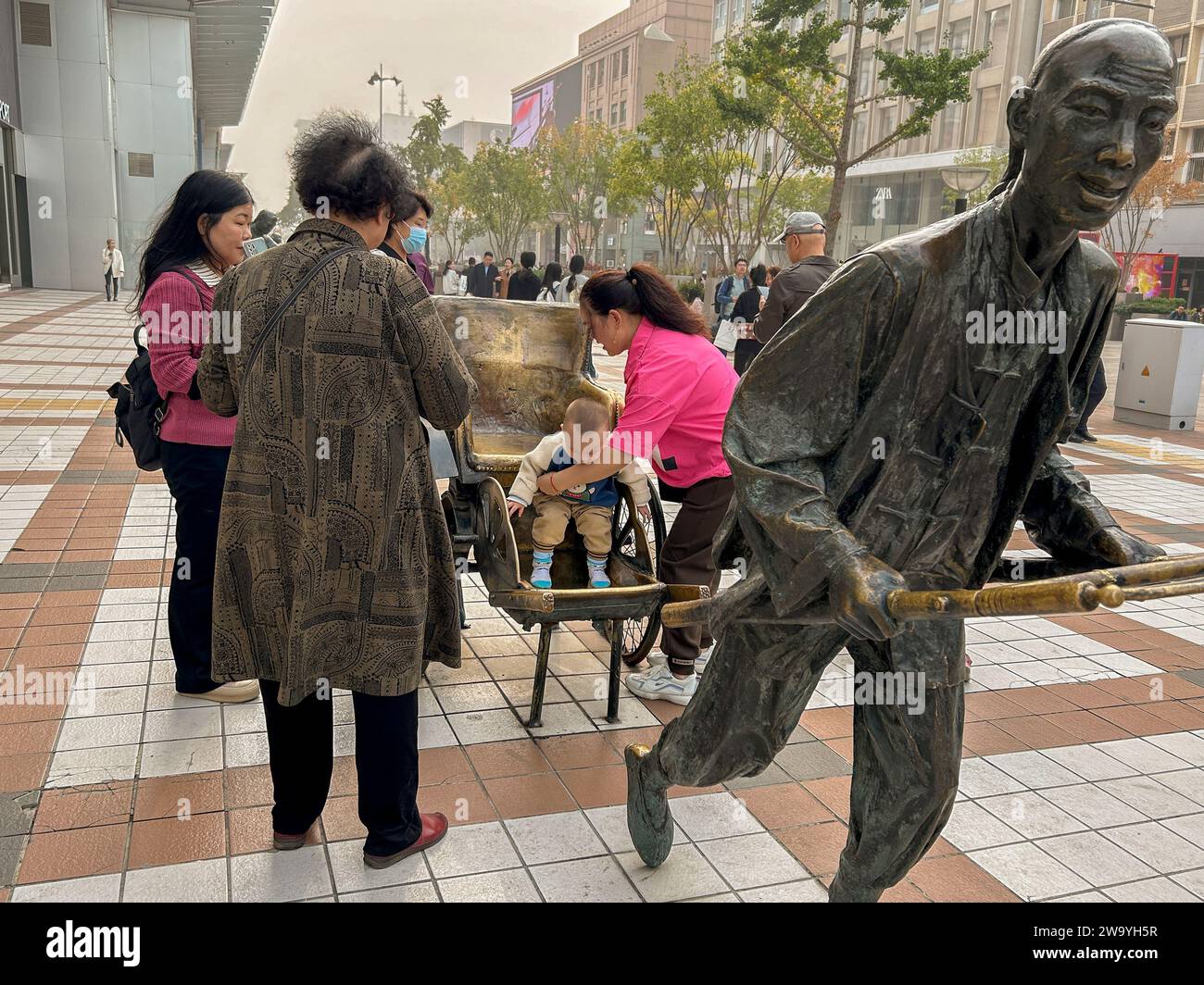 Peking, China, Straßenszene, kleine Menschenmenge, Familien, mit Kind und moderner Skulptur, Einkaufsstraße, Wangfujing St., Center City, Kunst Stockfoto