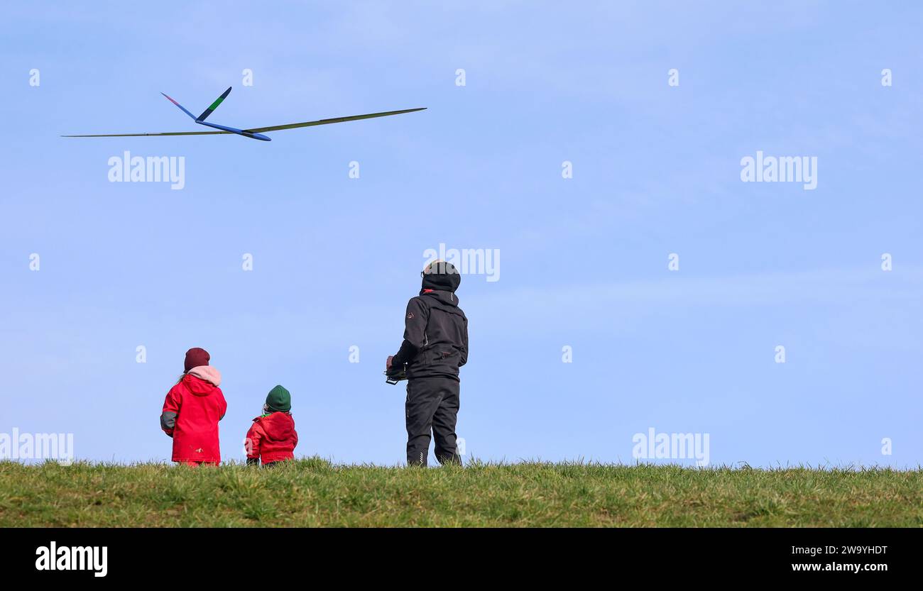 Bad Saulgau, Deutschland. Dezember 2023 31. Ein Vater und seine Kinder fliegen an Silvester einen Modellflieger in der Luft. Autor: Thomas Warnack/dpa/Alamy Live News Stockfoto