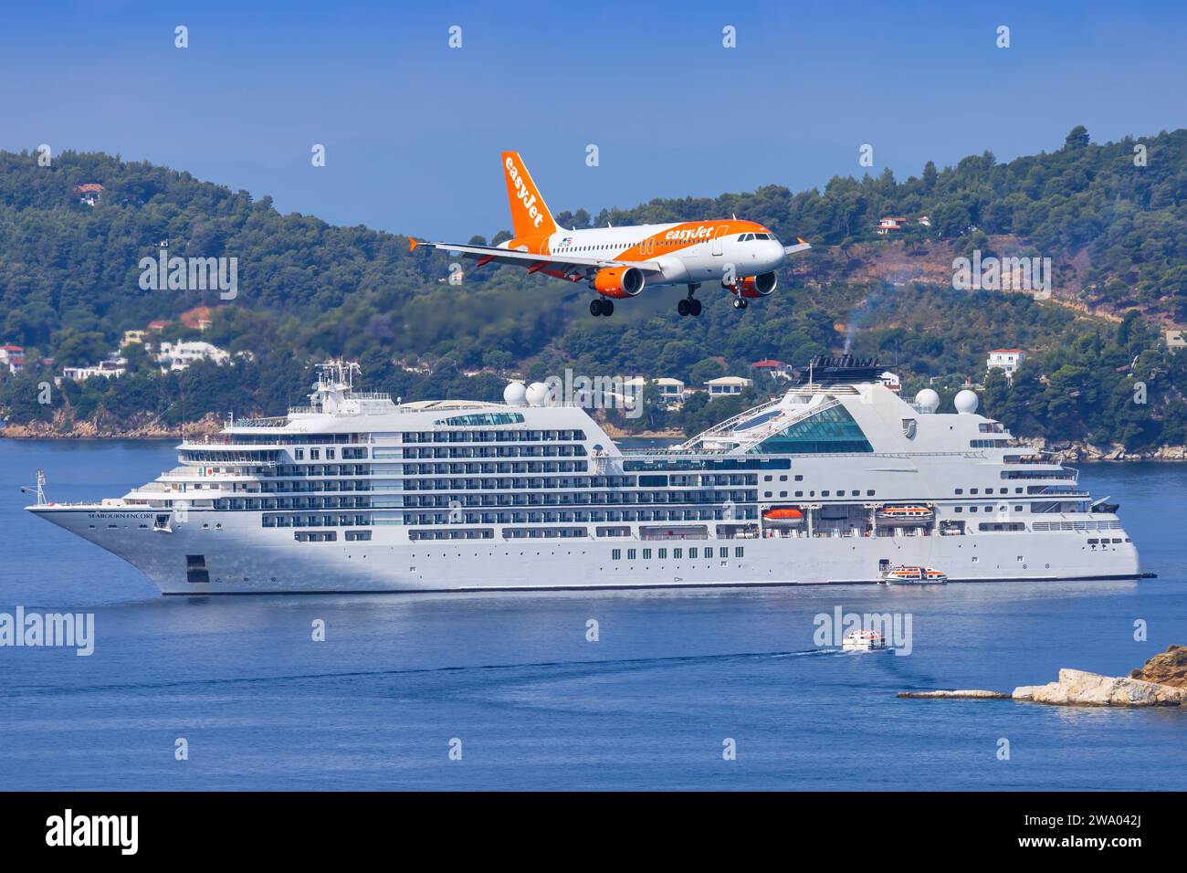 Skiathos, Griechenland - 24. August 2023: EasyJet A320 mit einem Boot im Hintergrund nähert sich dem Flughafen Skiathos Stockfoto