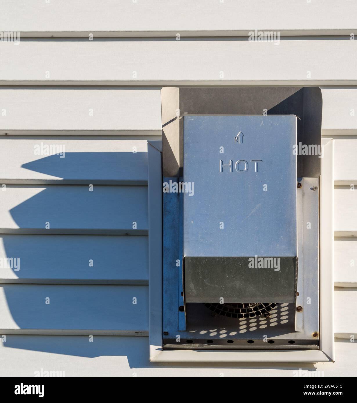 Schatten tanzen über eine weiße Vinylwand aus dem Abgas eines Gaskamin. Stockfoto