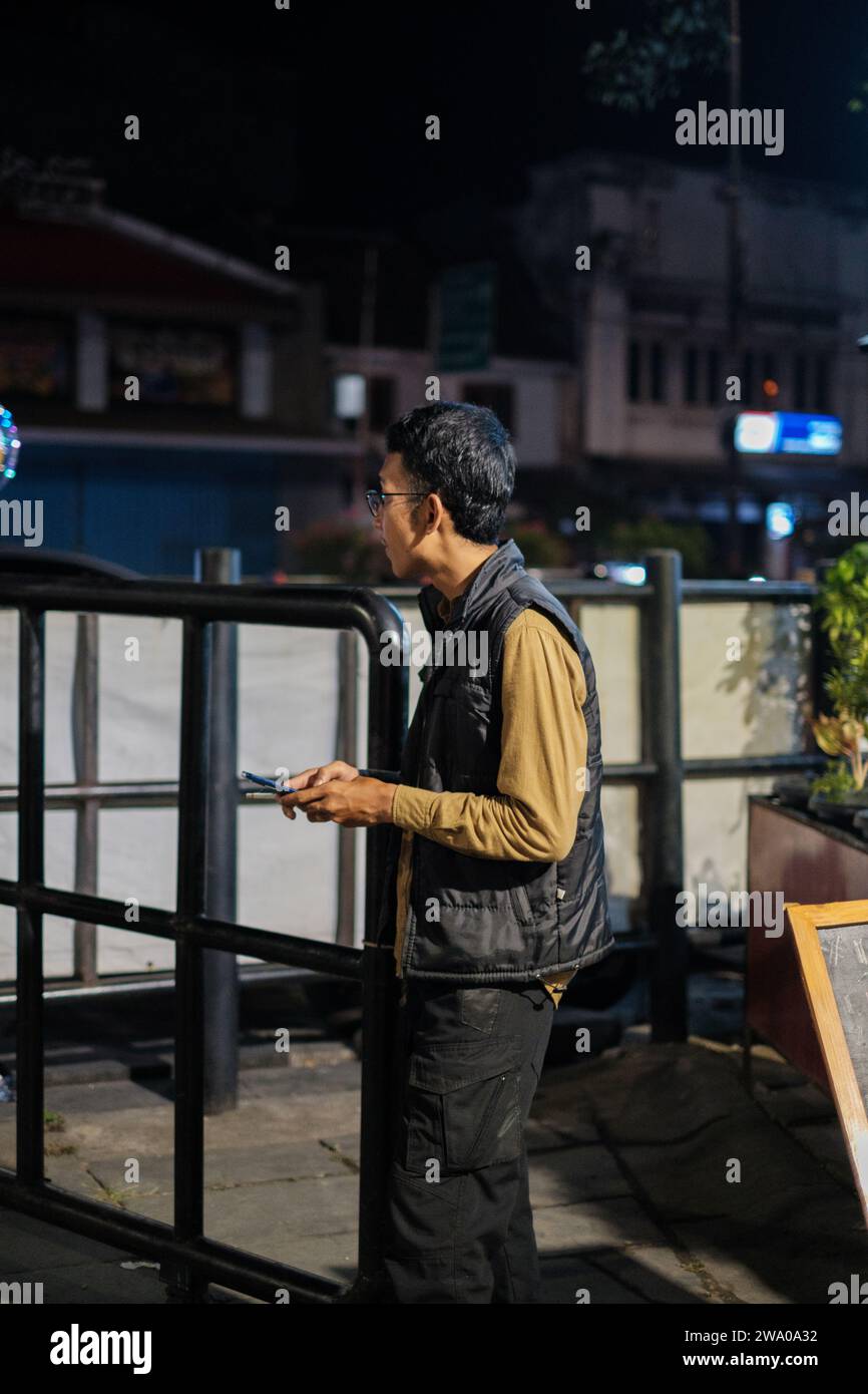 Jakarta, Indonesien - 2. Oktober 2023: Mann in Weste mit Telefon auf der Straße Stockfoto