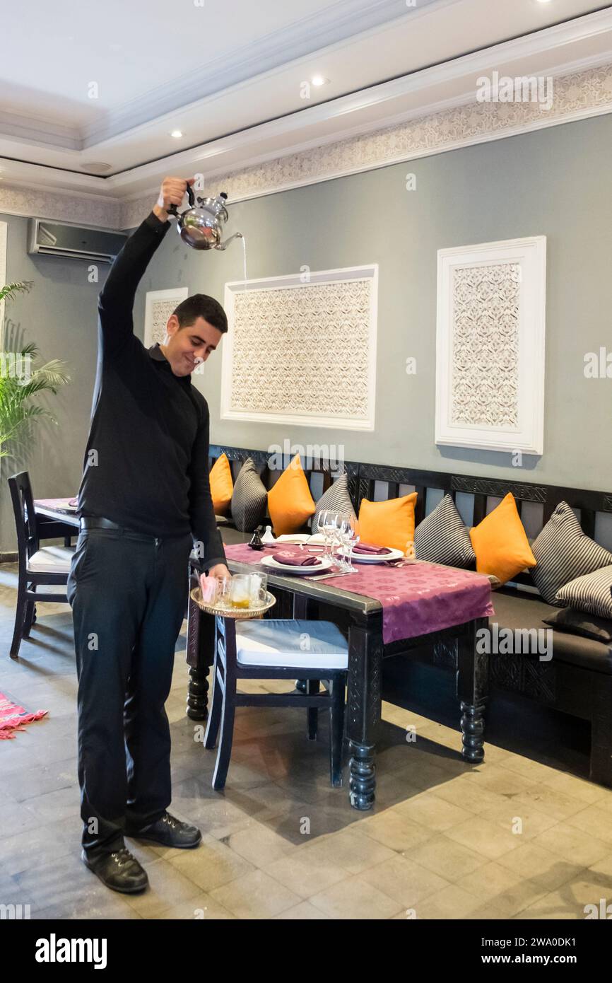 Der Restaurantbetreiber zeigt traditionelle Art, Minztee in Marrakesch, Marokko, zu gießen Stockfoto