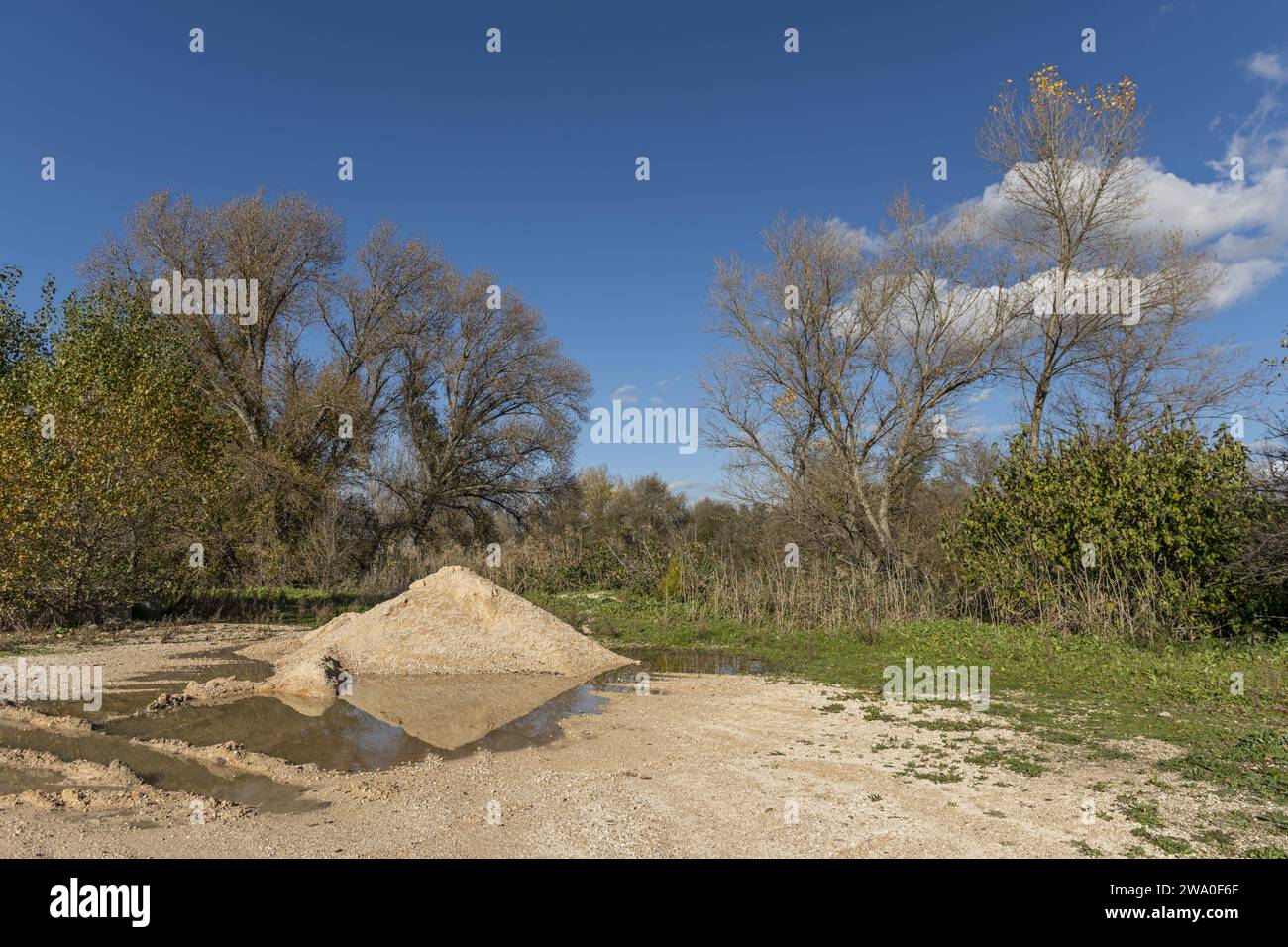 Eine Landlandschaft mit einem Sandhügel und einem Wasserbecken, in dem es reflektiert wird Stockfoto