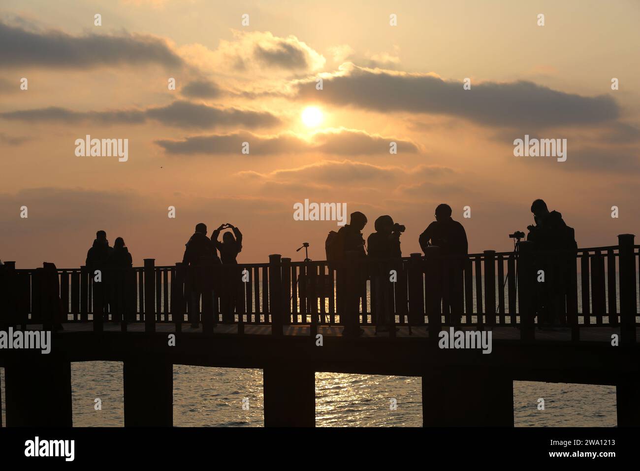LIANYUNGANG, CHINA - 1. JANUAR 2024 - die Bürger beobachten den Sonnenaufgang, um das neue Jahr an der Yangshan Island Uferpromenade in Lianyungang, Jiangsu, zu begrüßen Stockfoto