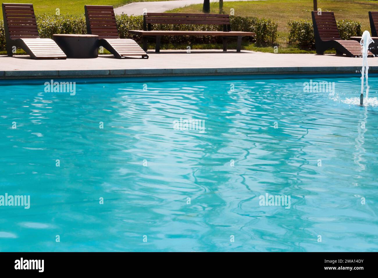 Holzstuhl und Tisch in der Nähe des Pools. Leerer Platz am Pool, Sommerhintergrund. Stockfoto