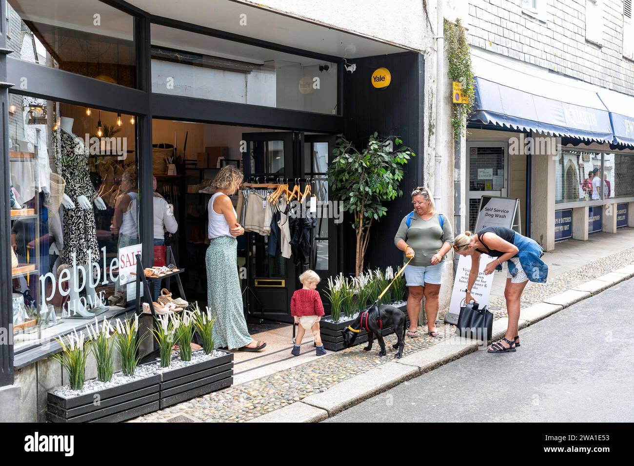 Looe Cornwall Town Centre, Damenboutique-Bekleidungsgeschäft Pebble mit weiblichen Käufern außerhalb, England, UK, 2023 Stockfoto