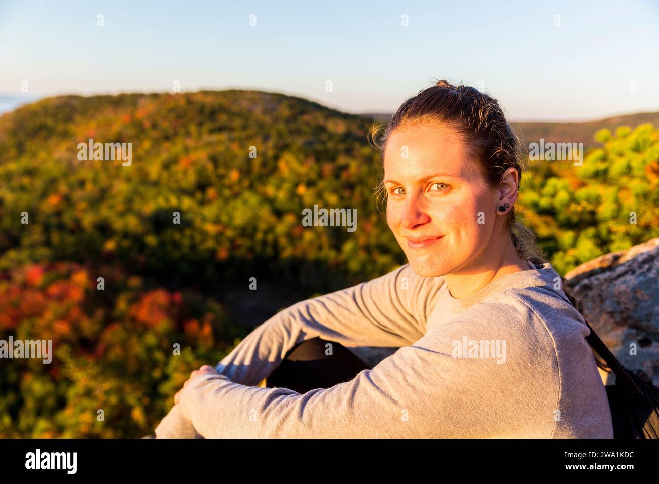 Frau, die sich beim Wandern auf dem Beehive Trail im Acadia-Nationalpark, Maine, USA, ausruhen kann Stockfoto