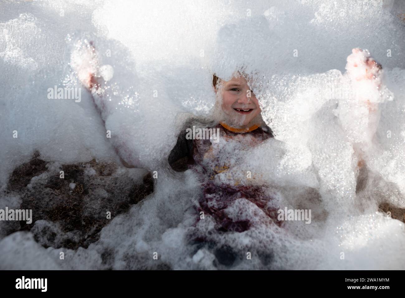 Das Kind ist mit Schaumblasen bedeckt Stockfoto