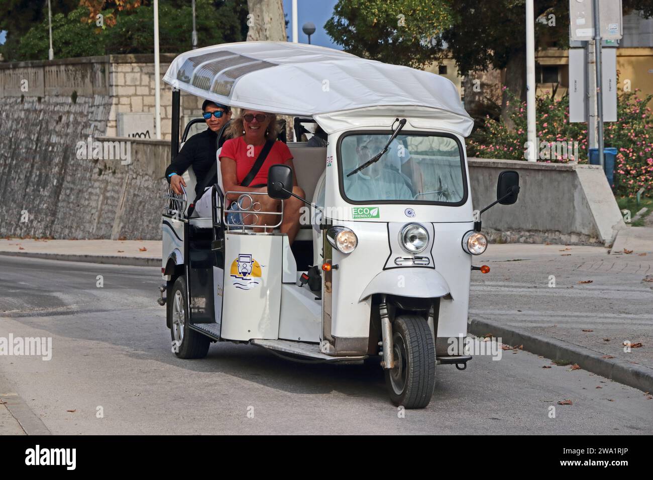 Touristisches elektrisches Tuk Tuk mit Touristen auf Besichtigungstour rund um Zadar, Kroatien Stockfoto