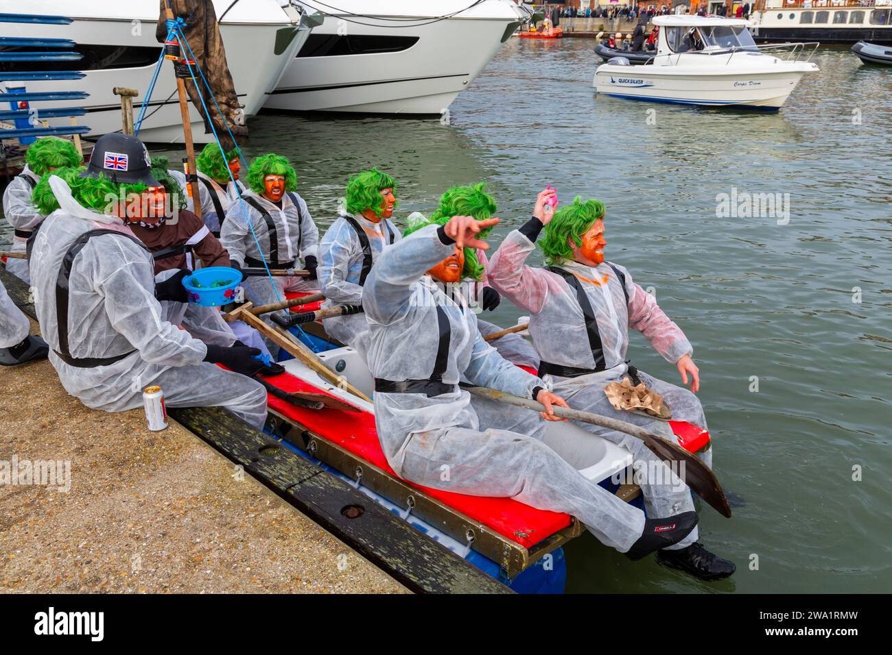 Poole, Dorset, Großbritannien. Januar 2024. Das New Year Day Bath Tub Race findet mit viel Nervenkitzel, Verschüttungen und Sabotage statt! Tausende sehen sich die Veranstaltung an, während eine Vielzahl ungewöhnlicher, hausgemachter Handwerkskunst zum Rennen aufs Wasser geht. Die Teilnehmer haben Spaß, werfen Eier und Mehl und kassieren konkurrierende Kunstwerke. Ein guter Start ins neue Jahr. Die oompa loompas machen sich mit ihren grünen Haaren und orangefarbenen Gesichtern bereit. Quelle: Carolyn Jenkins/Alamy Live News Stockfoto