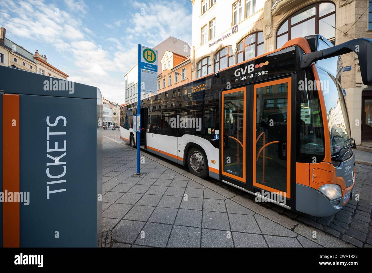 PRODUKTION - 22. Dezember 2023, Sachsen, Görlitz: Am Demiani-Platz in Görlitz steht ein Fahrkartenautomat der Görlitzer Verkehrsbetriebe (GVB). Daneben befindet sich ein Bus der Linie A, der nach Zgorzelec in Polen fährt. Das Anfang 2023 eingeführte europäische Stadtticket für Görlitz und die benachbarte polnische Stadt Zgorzelec hat sich nach Angaben der Betreiber in der grenzüberschreitenden Praxis bewährt. Foto: Paul Glaser/dpa Stockfoto