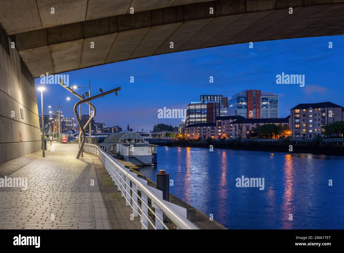 Glasgow Stadt von der Brücke unter der Promenade am Fluss Clyde bei Nacht in Schottland, Großbritannien. Stockfoto
