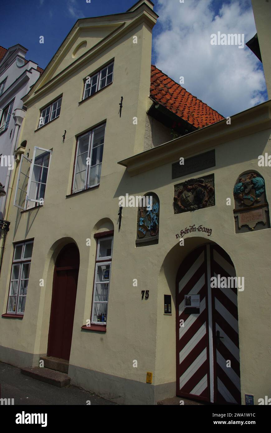 Stadthaus mit Bogengang, dekoriert mit Wandmalereien und mit Chevron bemalten Toren, Lübeck, DDR Stockfoto