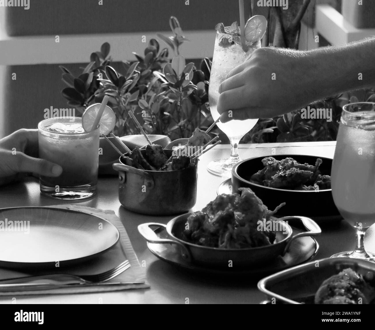 Cocktailgetränke und gepaarte Speisen auf einem Esstisch Stockfoto