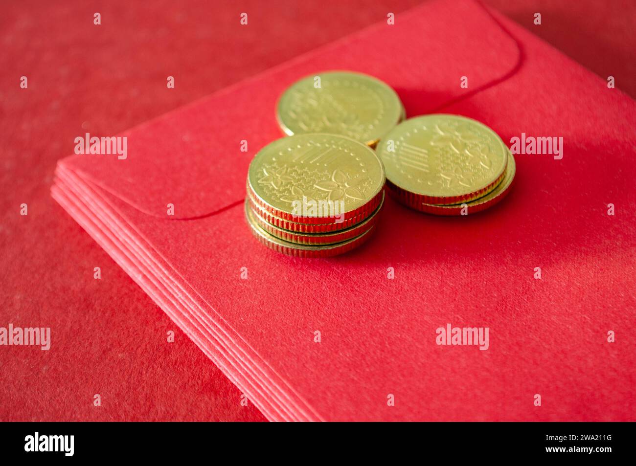 Goldmünzen auf den roten Päckchen des chinesischen Neujahrs. Stockfoto