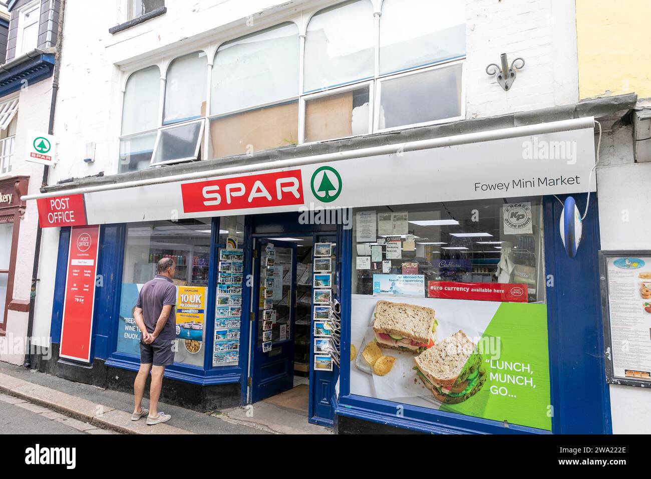 Spar Supermarkt und Minimarkt in der kornischen Stadt Fowey, mit Mann stand draußen, England, UK, 2023 Stockfoto