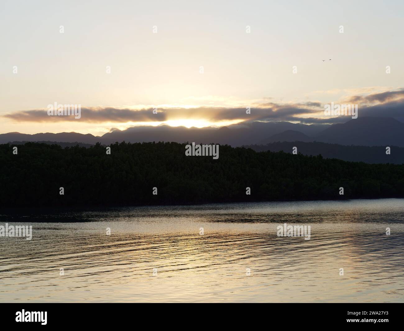 Blick auf den Sonnenuntergang über den fernen Hügeln in Port Douglas Queensland Australien Stockfoto