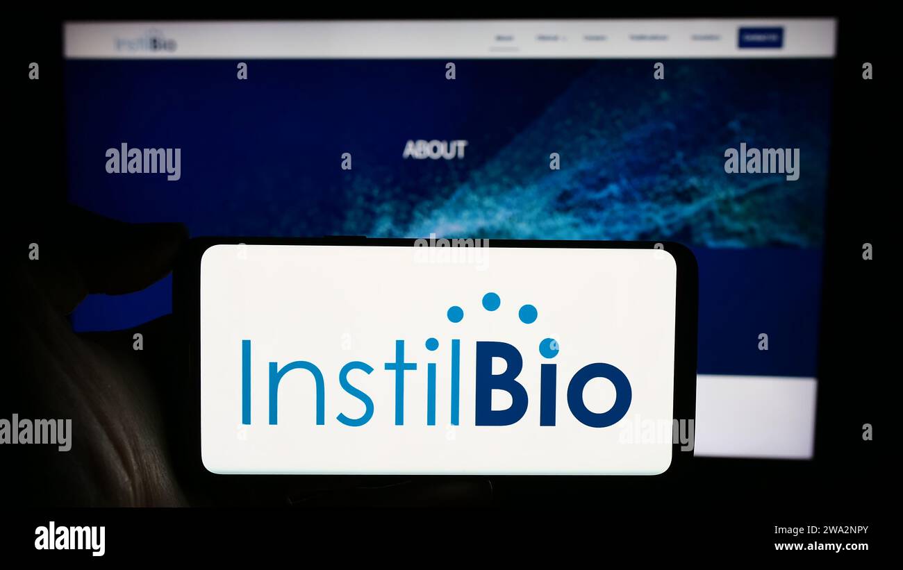 Person, die ein Mobiltelefon mit dem Logo des US-amerikanischen Biotechnologie-Unternehmens Instil Bio Inc. Vor der Business-Website hält. Schwerpunkt auf dem Display des Telefons. Stockfoto