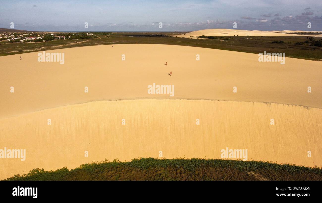 Die Sanddünen mit ihren Farbtönen in Jeriocoacoara in Brasilien, der Strand, die lange felsige Küste und die Bäume Palmen Stockfoto