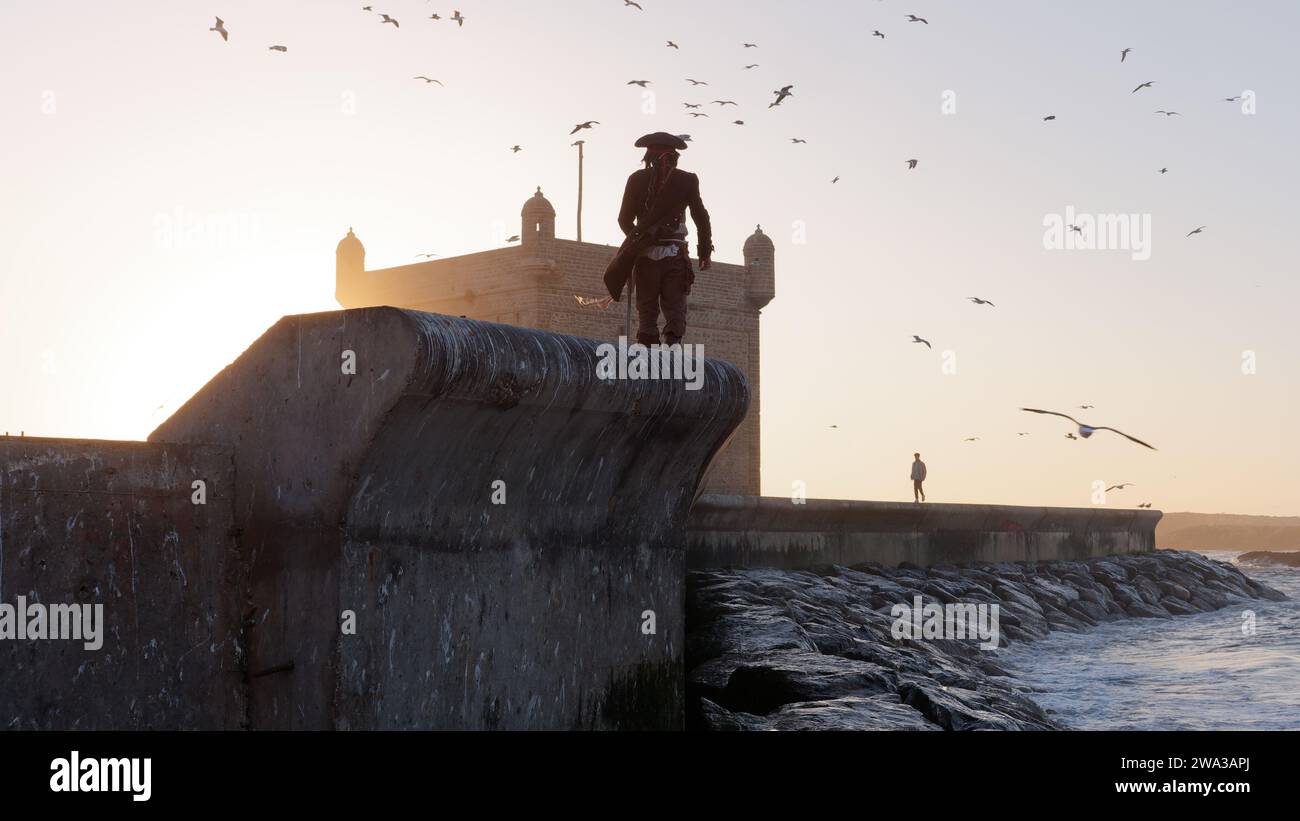 Mann in Piratenkostüm geht an einem Winterabend in Essaouira, Marokko, am 1. Januar 2024 durch die Stadtmauern am Fort Stockfoto