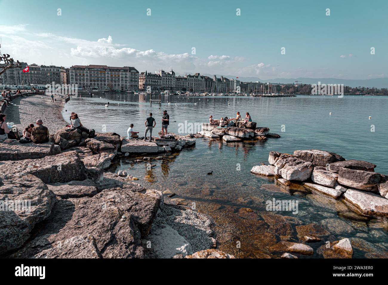Genf, Schweiz - 25. März 2022: Menschen genießen den malerischen Blick auf den Genfer See an der Bucht von Genf, dem französischen Teil der Schweiz. Stockfoto