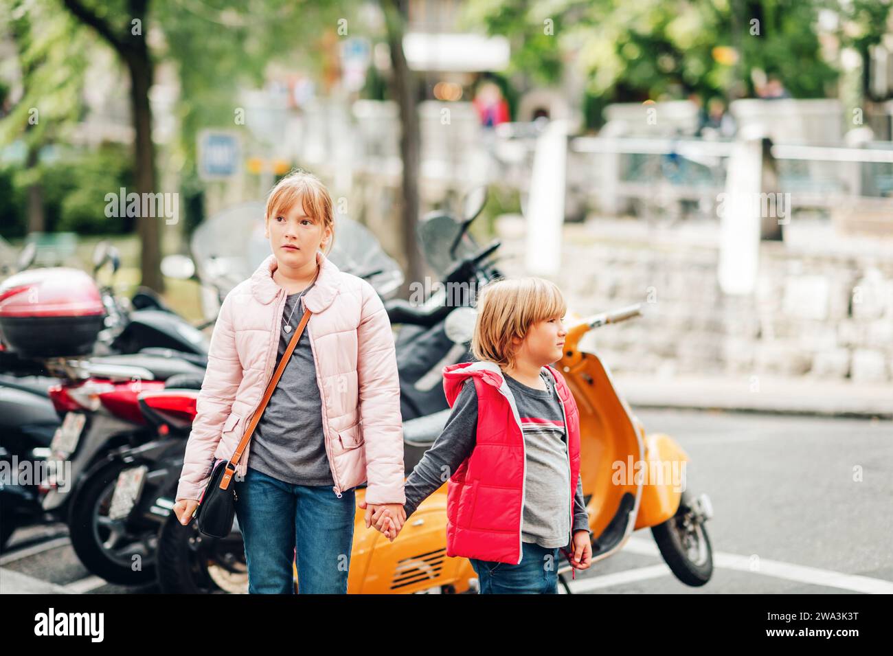 Street Fashion für Kinder. Junge und Mädchen tragen gepolsterte Jacken. Kleiner Bruder und Schwester verbringen Zeit miteinander Stockfoto