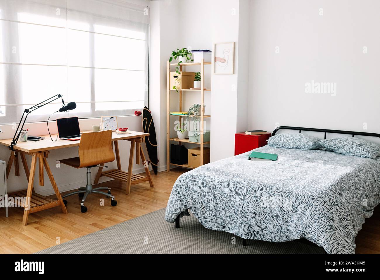 Gemütliches, innenliegendes Teenager-Zimmer mit Bett und Schreibtisch Stockfoto