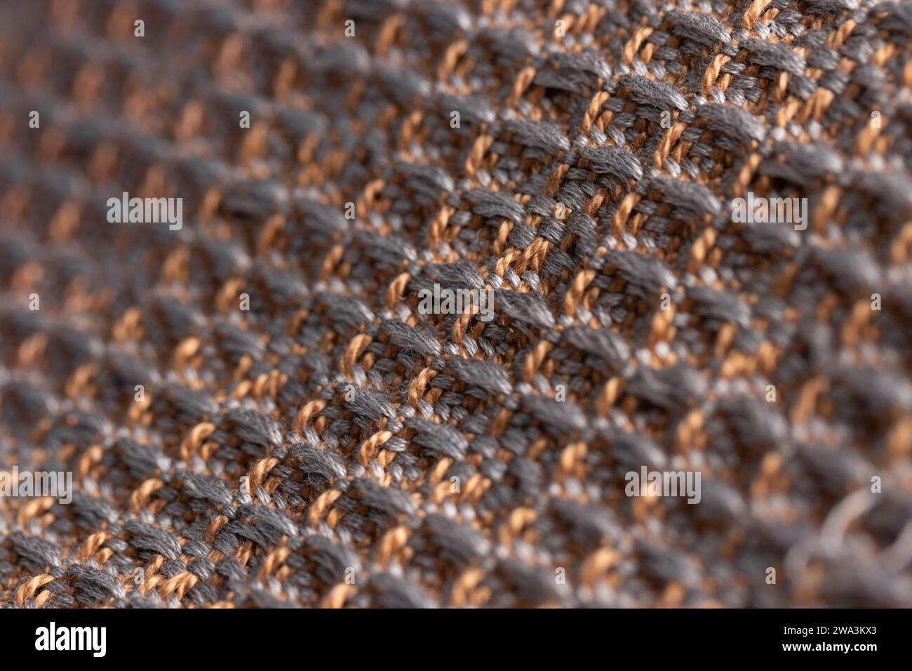 Drapiertes Gewebe, gewebt mit Waffelwebertechnik in Braun und Grau, Makroaufnahme mit Nahaufnahme und geringer Schärfentiefe Stockfoto