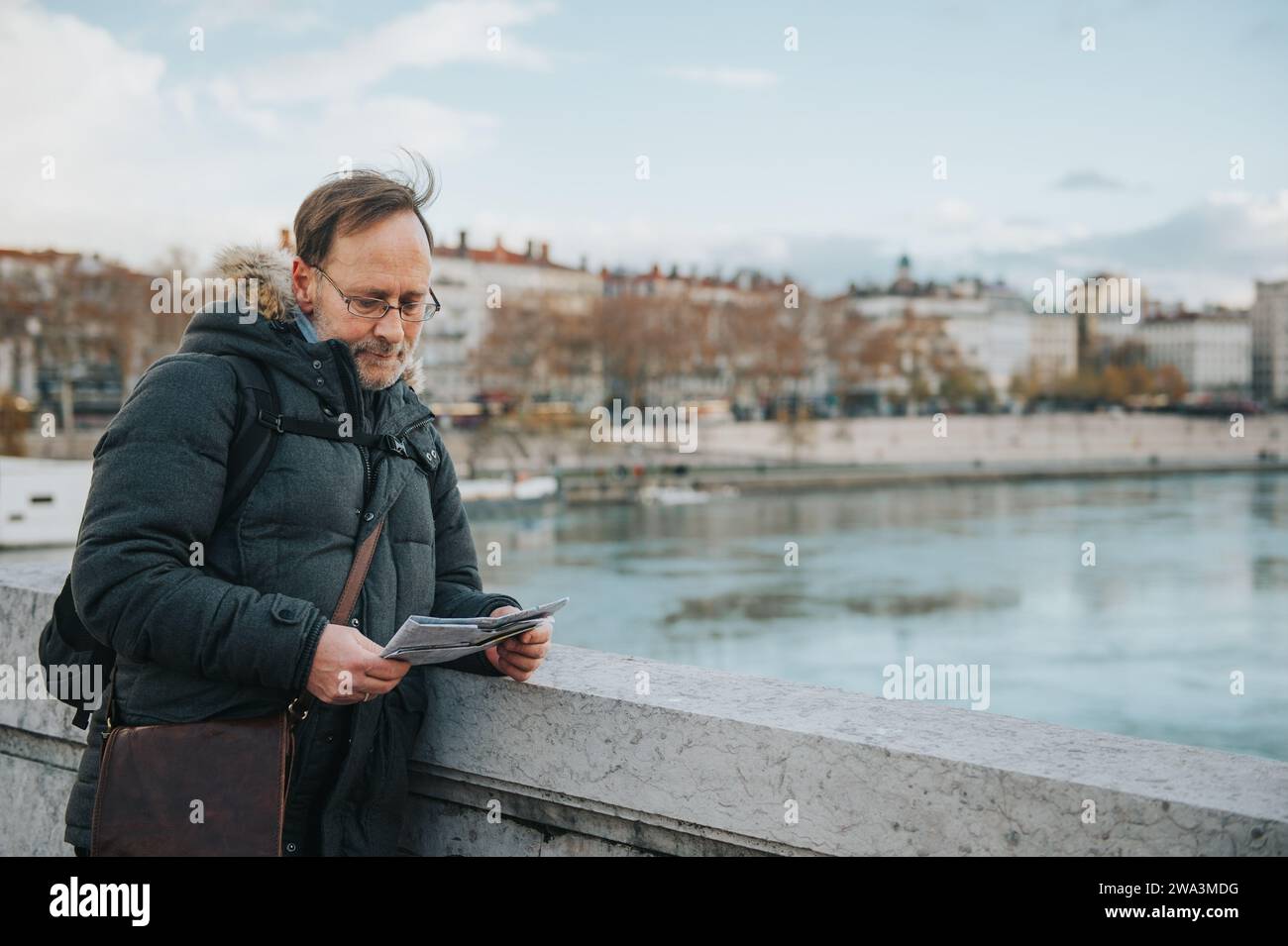 Mann Tourist mit Rucksack und Karte bewundern Sie den Fluss Rhone von der Bonaparte Brücke, Lyon, Frankreich. Stockfoto