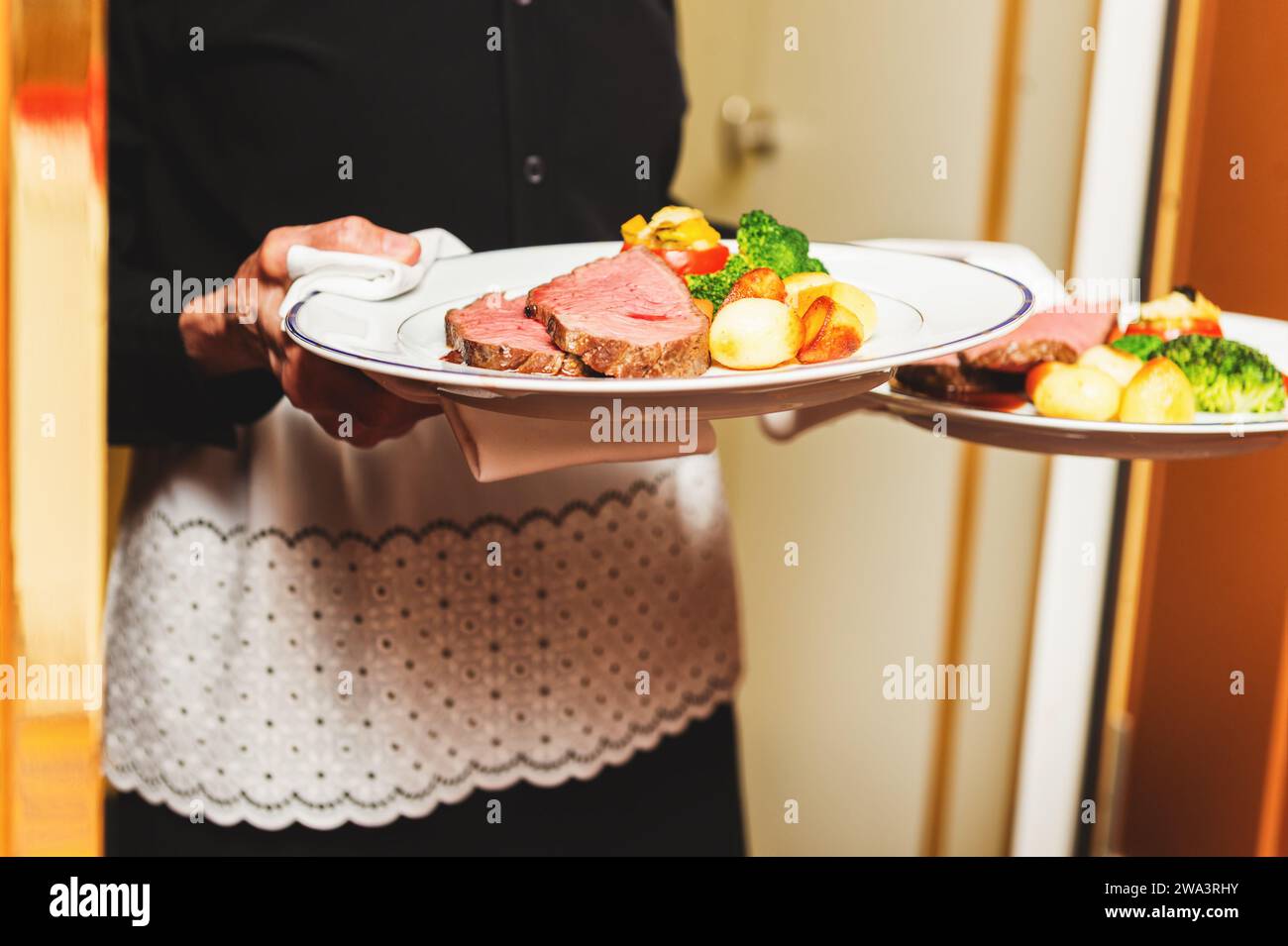 Kellner mit zwei Platten mit Fleisch auf einige festliche Veranstaltung, Party, Hochzeit oder Event Catering Stockfoto