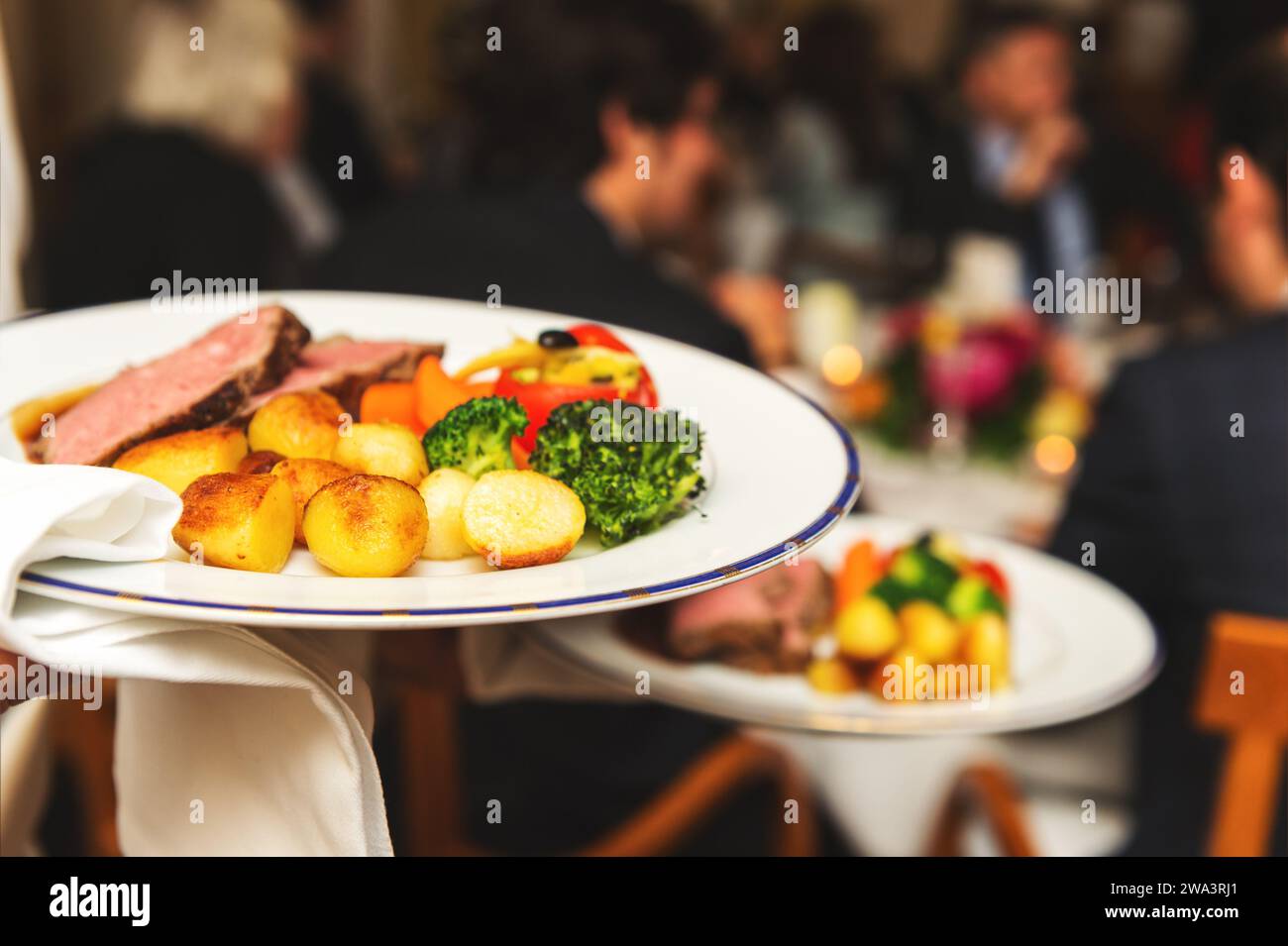 Kellner mit zwei Platten mit Fleisch auf einige festliche Veranstaltung, Party, Hochzeit oder Event Catering Stockfoto