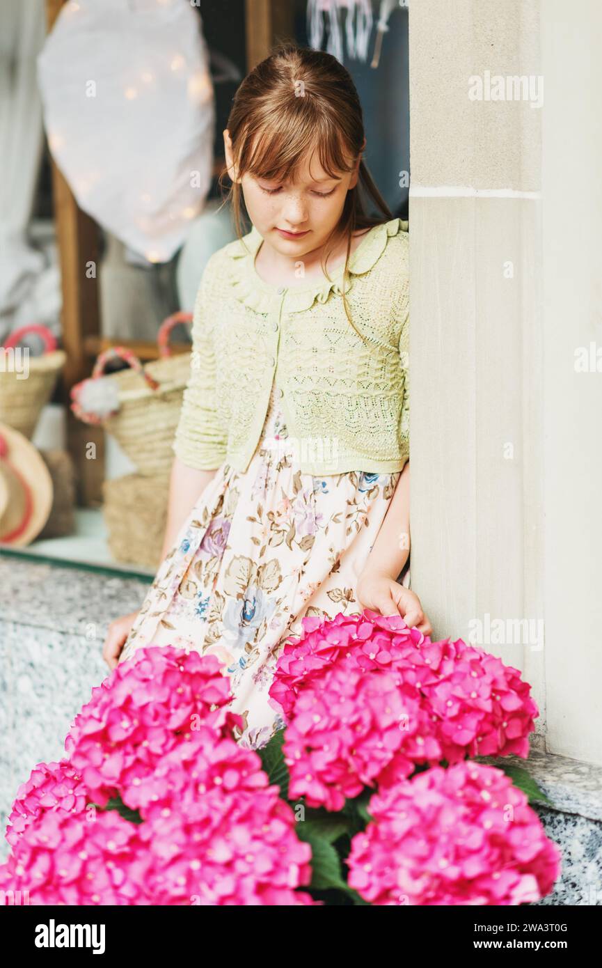 Außenporträt eines hübschen 9-10-jährigen Mädchens, das Sommerkleid trägt Stockfoto