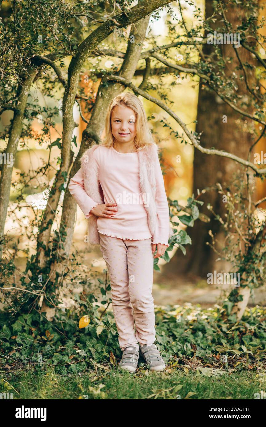 Außenporträt eines niedlichen kleinen Mädchens, das im Park spielt, Kind, das an einem schönen warmen sonnigen Tag Spaß hat Stockfoto