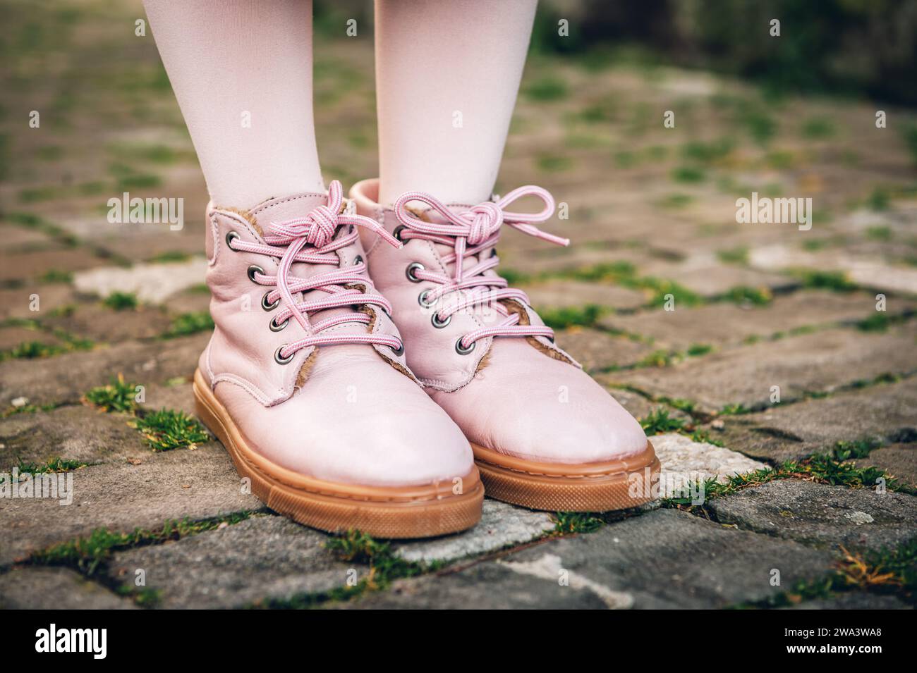 Pinkfarbene Schuhe auf Kinderfüßen Stockfoto