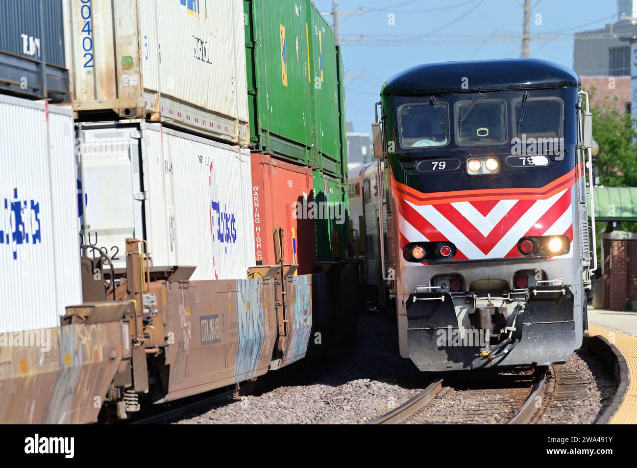 Wheaton, Illinois, USA. Ein Metra-Pendlerzug auf einer Kurve, der an einem lokalen Vorort-Gemeindededepot ankommt. Stockfoto