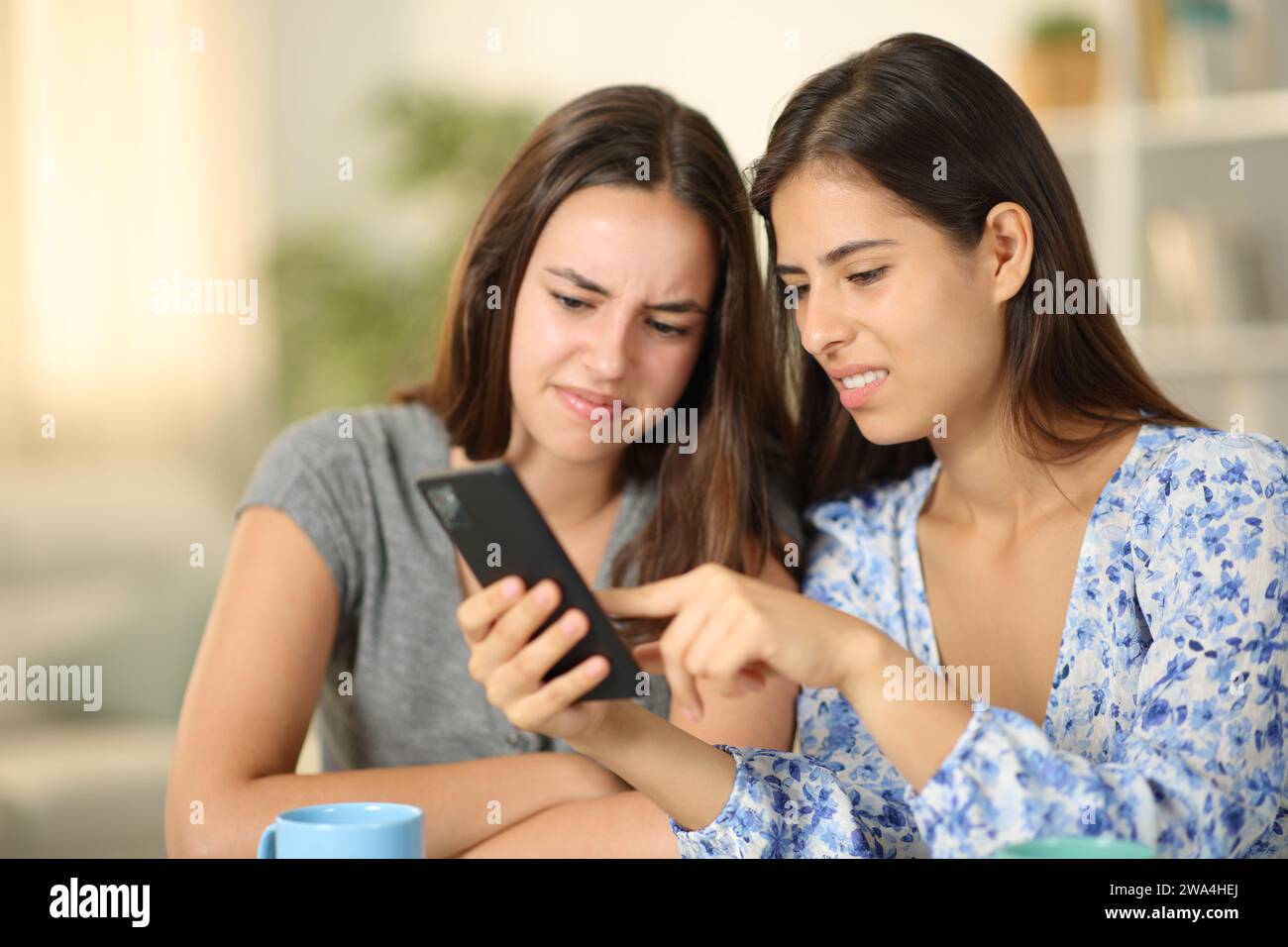 Angewischte Freunde sehen sich Medieninhalte zu Hause auf dem Telefon an Stockfoto