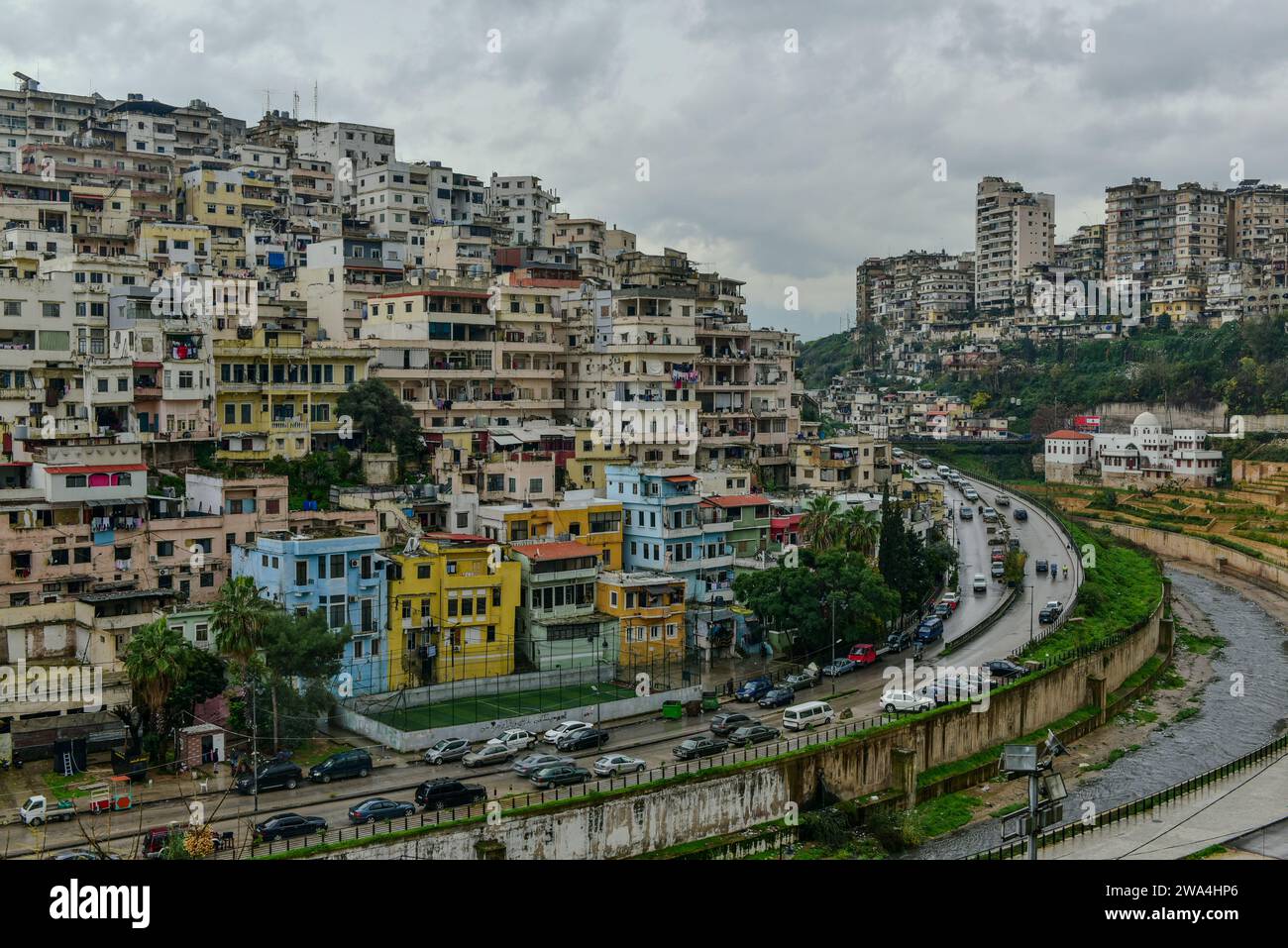 Blick auf eine Wohngegend auf einem Hügel über dem Fluss Abou Ali von der Zitadelle von Tripoli an einem düsteren Wintertag. Tripolis, Libanon Stockfoto
