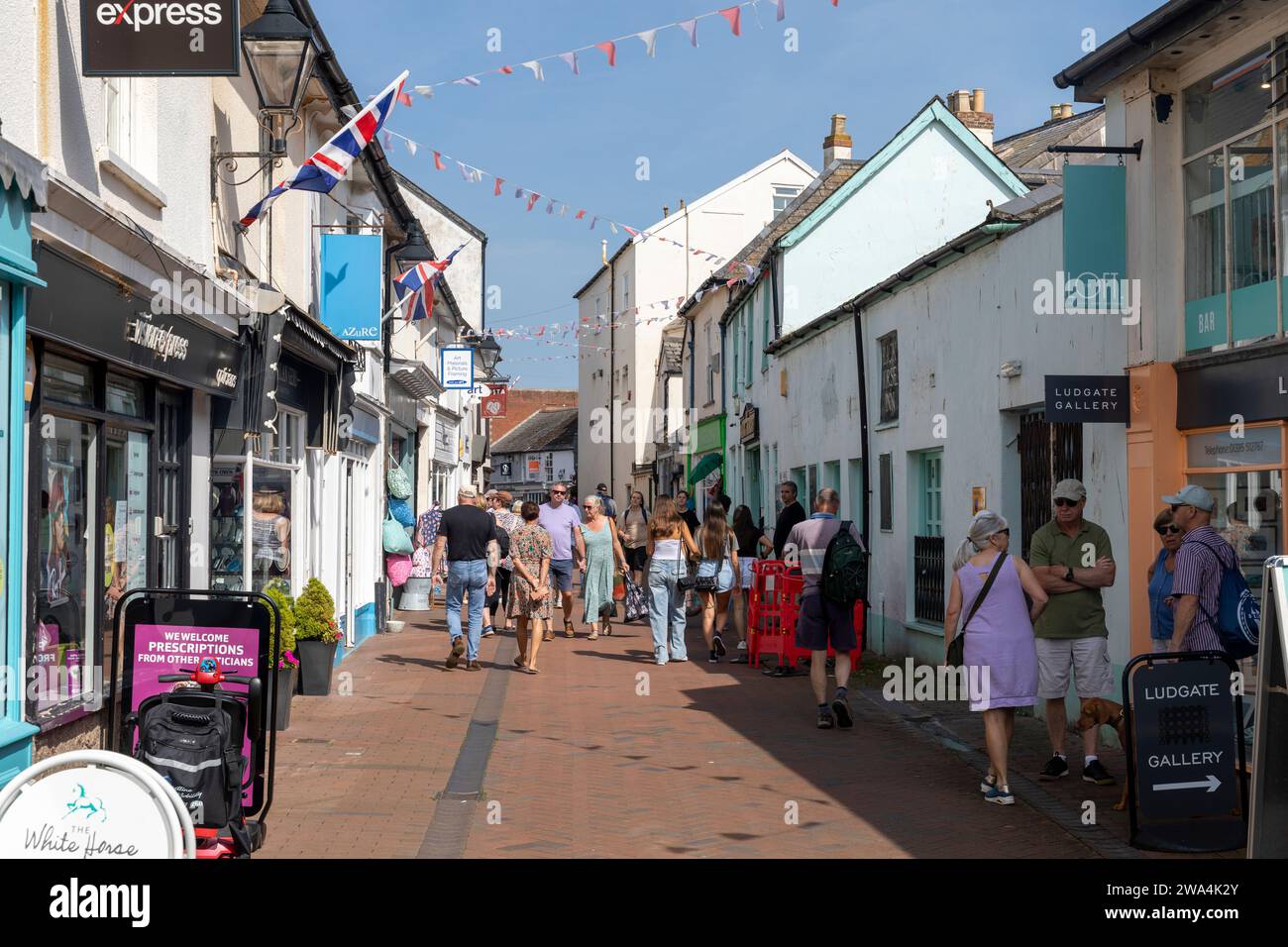 Sidmouth Devon 2023, Shopper im Stadtzentrum spazieren an einem warmen sonnigen Septembertag vorbei an Geschäften, England, Großbritannien Stockfoto