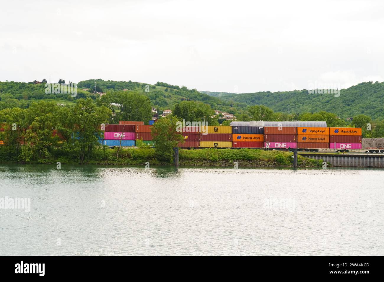 Lyon, Frankreich - 7. Mai 2023: Frachtcontainer am Eisenbahncontainer-Terminal in der Nähe des Flusses. Internationale Frachtlogistik Stockfoto