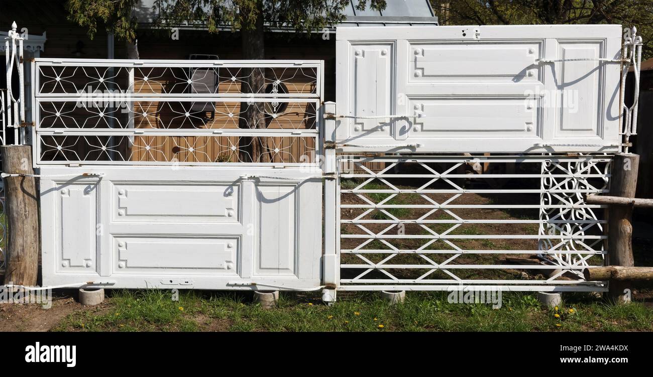 Rustikaler Zaun aus alten weißen Türen Stockfoto
