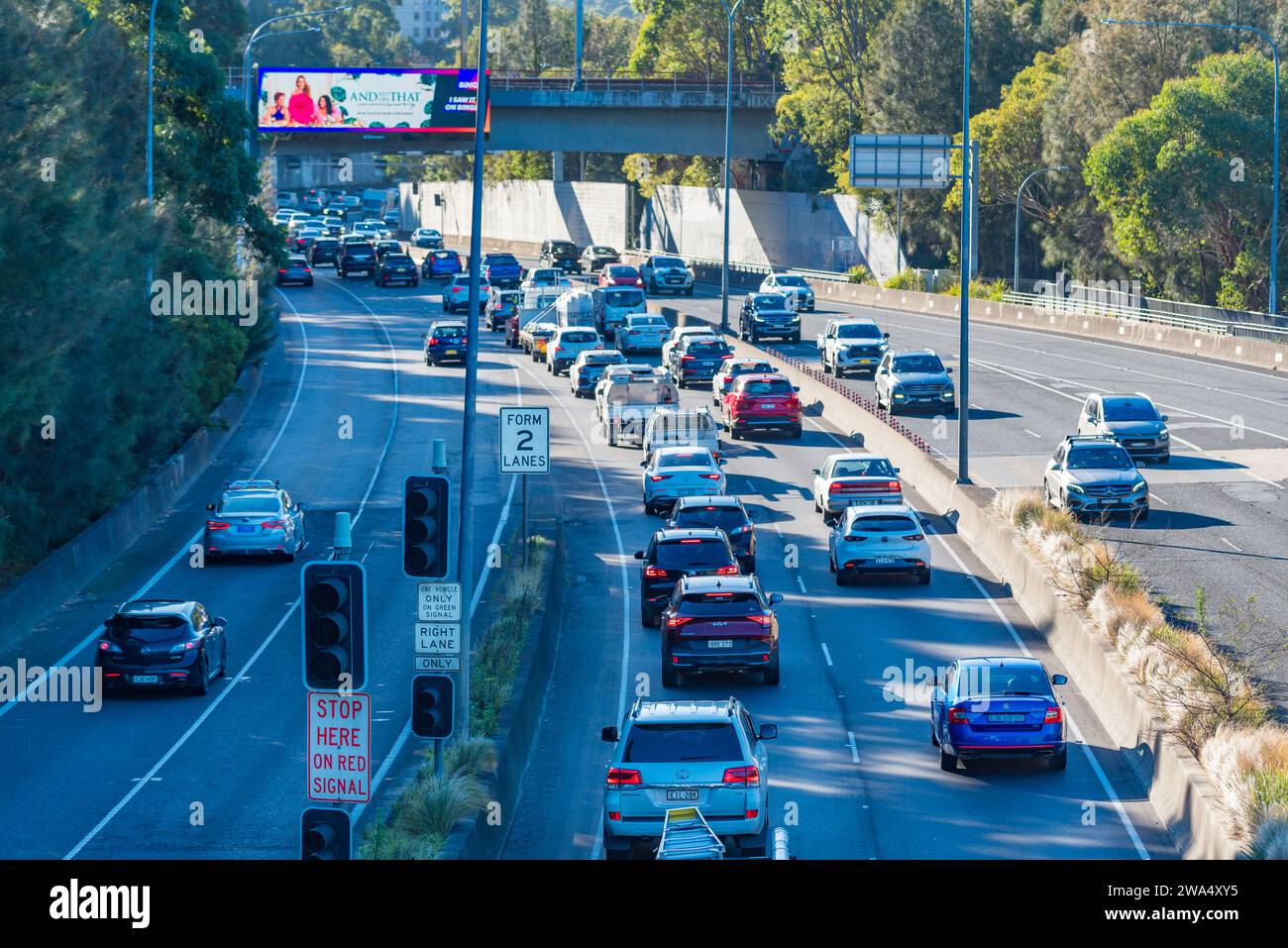 Eine elektronische Plakatwand über dem Straßenverkehr am Morgen auf dem Gore Hill Expressway im Norden von Sydney, Australien Stockfoto