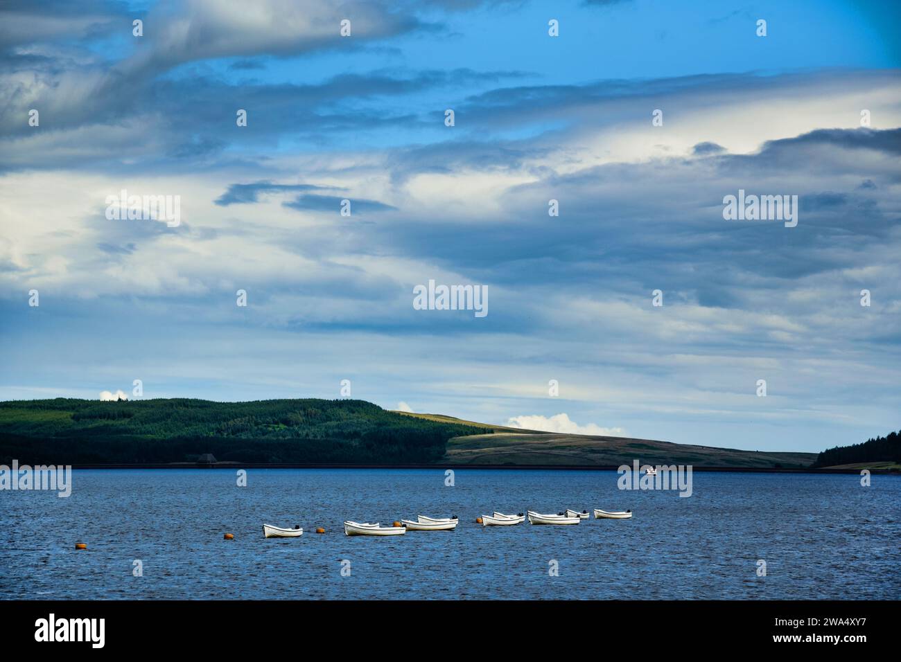 Boote, die entlang eines Sees/Stausees treiben. Hügel auf dem Land. Ruhiges Wasser. Hintergrund Wald/Wald. Großbritannien. UK. Stockfoto