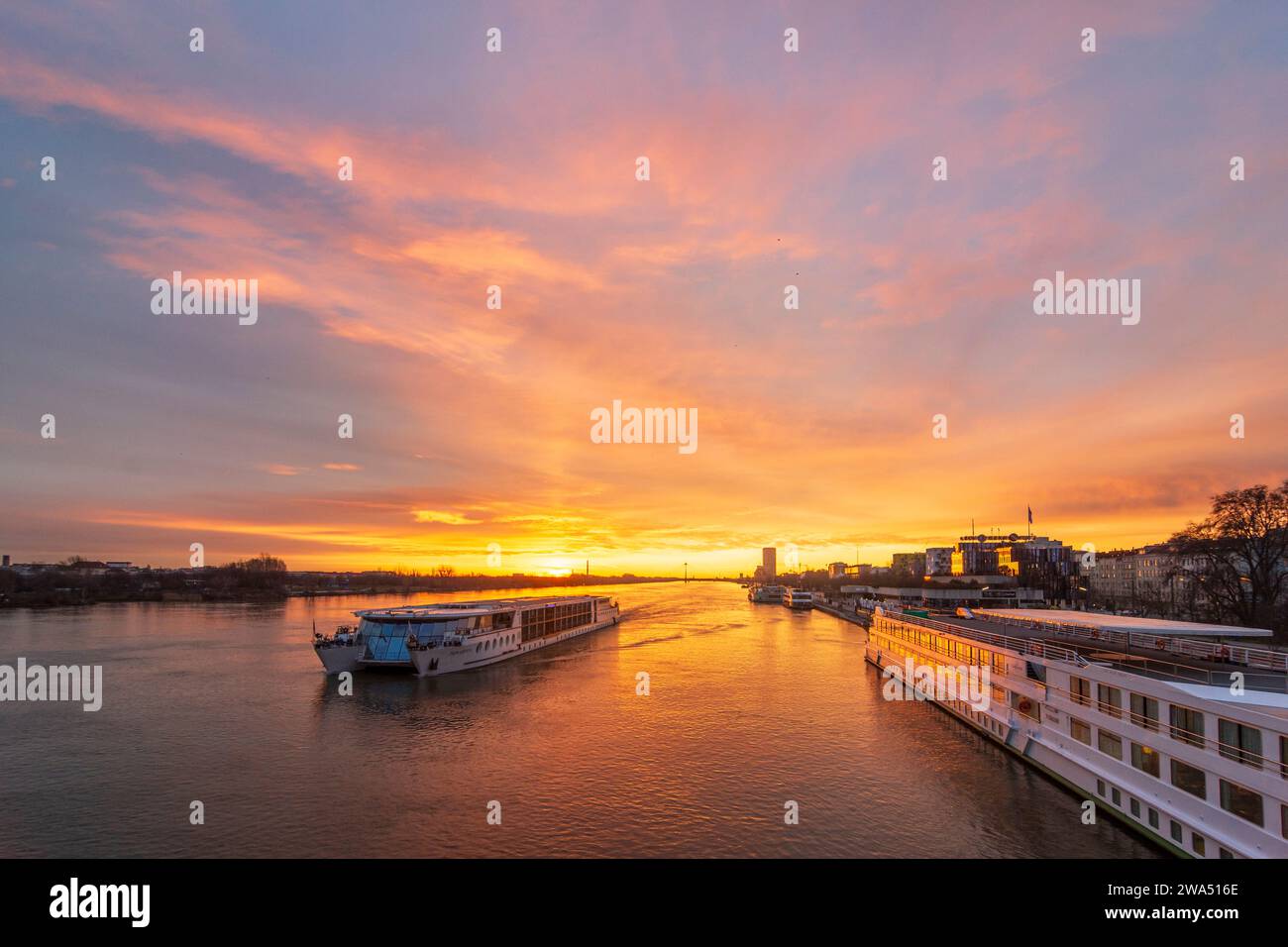 Wien: Donau bei Sonnenaufgang, Kreuzfahrtschiffe, Bootsanleger, Donaustadtbrücke, Marina Tower in 02. Leopoldstadt, Wien, Österreich Stockfoto