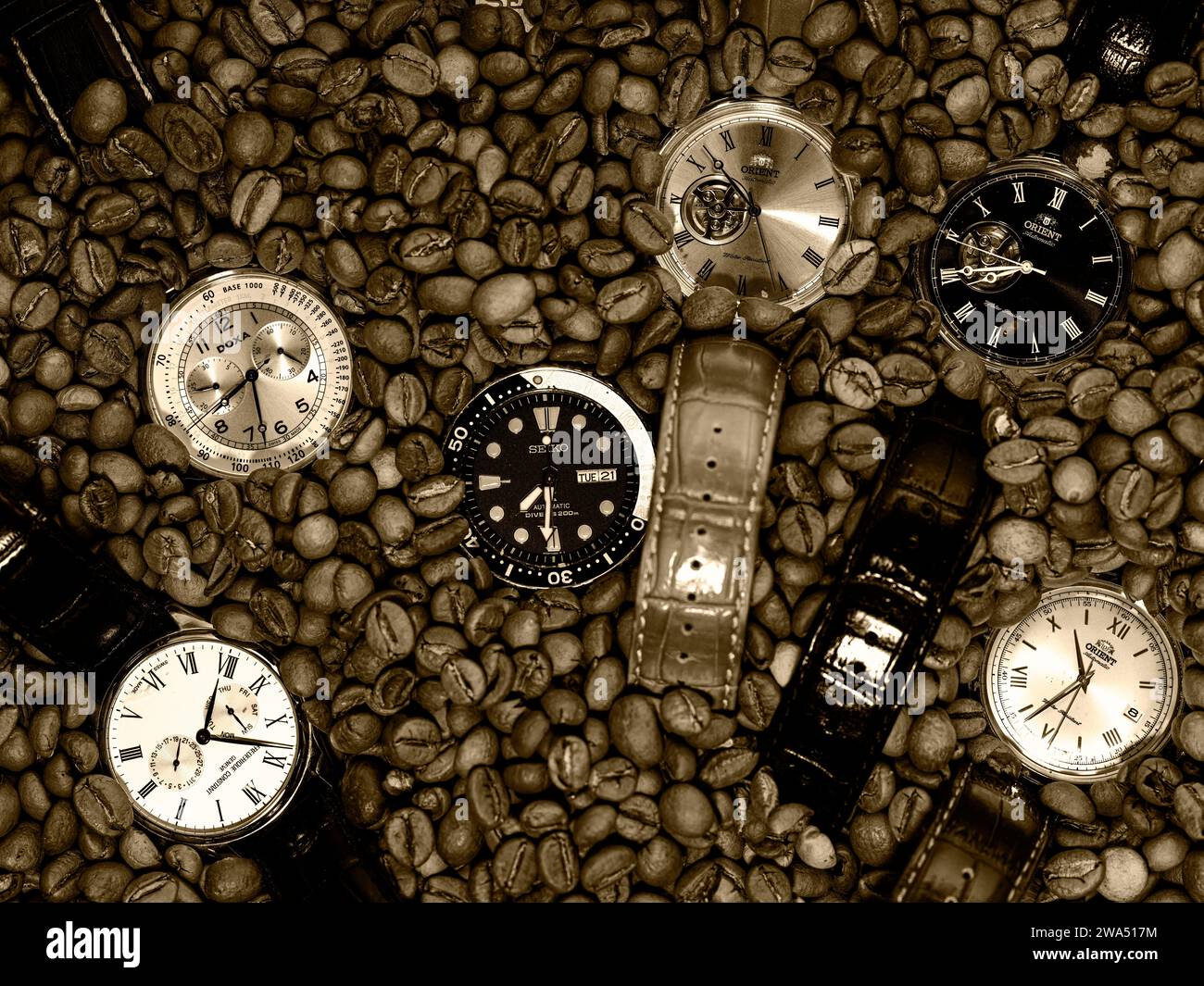 Kaffeezeit - sechs Armbanduhren und Kaffeebohnen auf einem Tisch Stockfoto
