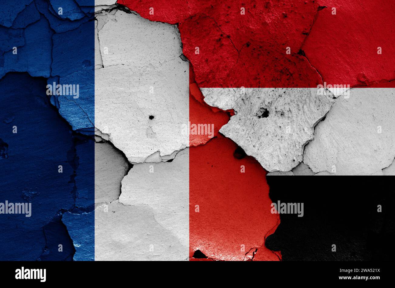 Flaggen von Frankreich und Jemen auf zerrissene Wand gemalt Stockfoto