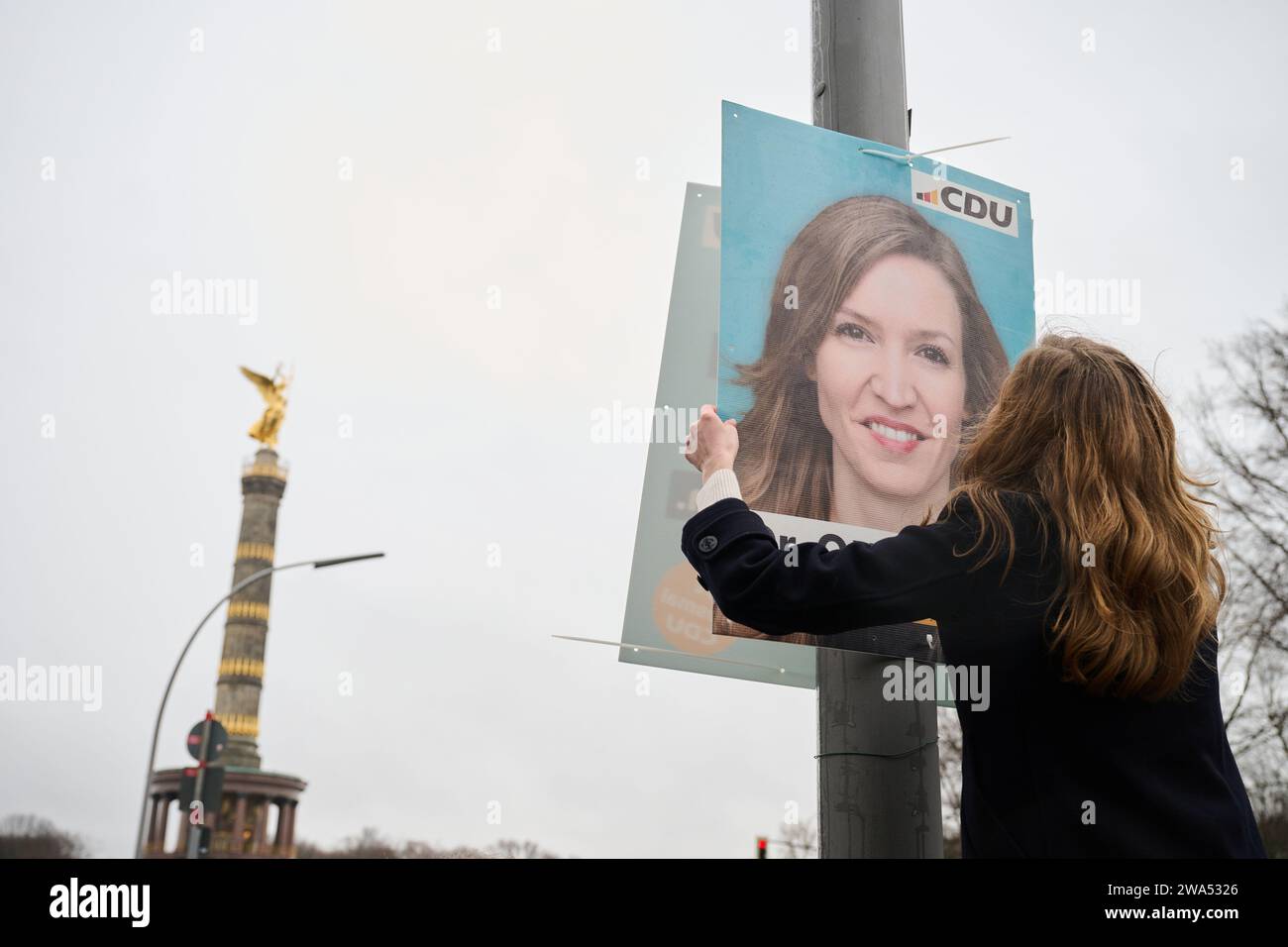 Berlin, Deutschland. Januar 2024. Ottilie Klein (CDU), direkte Kandidatin für den Wahlkreis Berlin-Mitte und Generalsekretärin, hängt ein Plakat mit ihrem Bild vor die Siegessäule. In Berlin muss die Bundestagswahl in einigen Wahlkreisen wiederholt werden. Annette Riedl/dpa/Alamy Live News Stockfoto